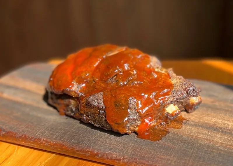 Glazed BBQ pork ribs on a wooden board at Sunday Best Seoul