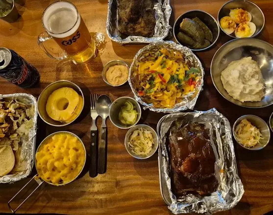 Full table spread at Sunday Best Seoul â€” ribs, nachos, mac and cheese, mashed potatoes and Cass beer